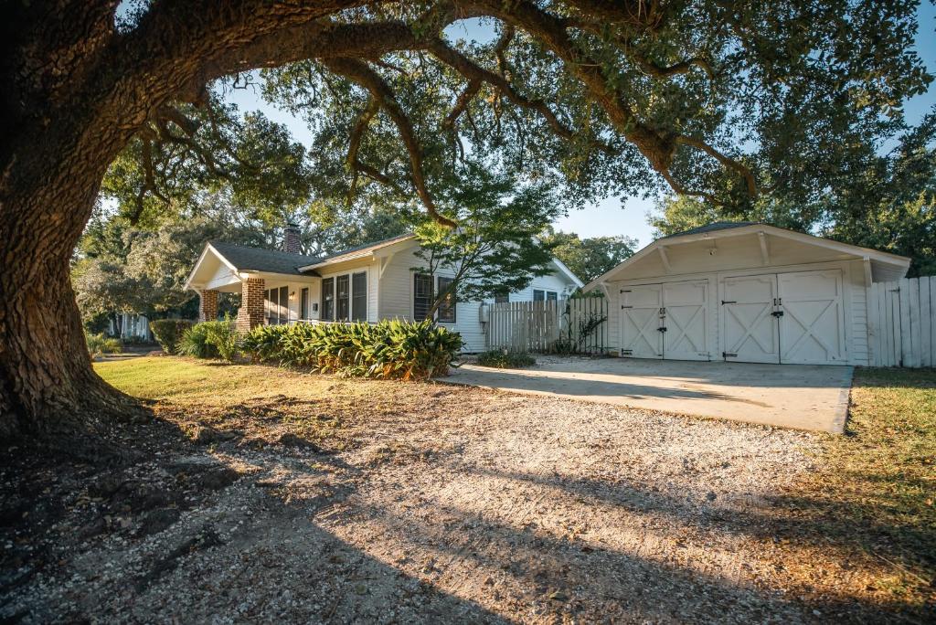 格尔夫波特Gulf Coast Craftsman - Cozy, Charming & Central!的一座房子,有白色的车库和一棵树