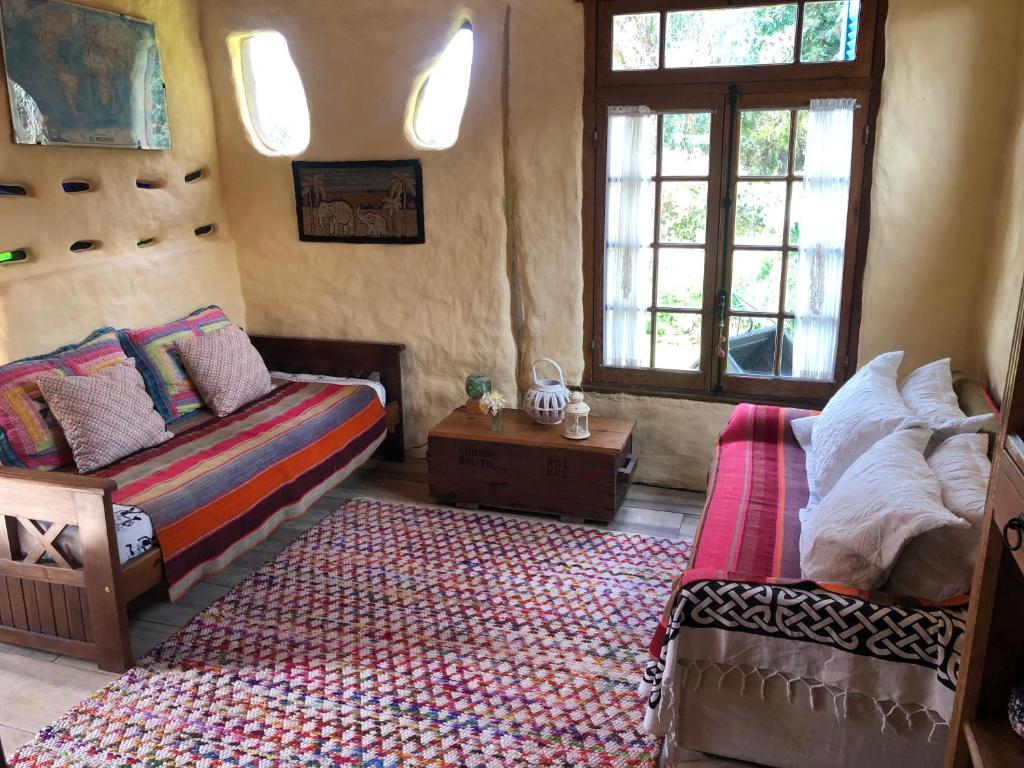 库奇拉阿尔塔Todo se transforma的一间卧室配有一张床、一张沙发和窗户。