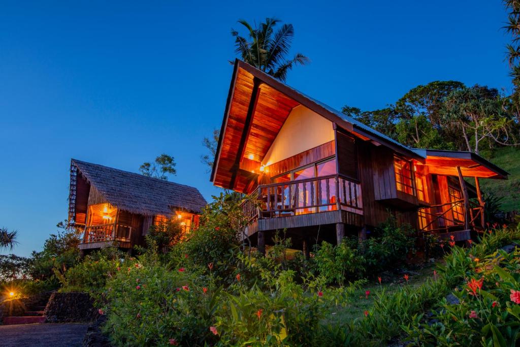 科罗尔Palau Carolines Resort的山上的一座房屋,灯光照亮