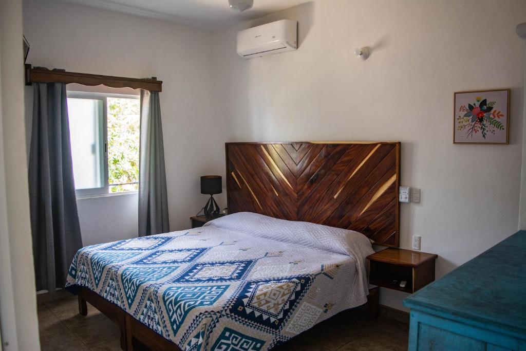 圣法兰西斯克DownTown Rooms San Pancho的一间卧室配有一张带木制床头板的床和窗户。