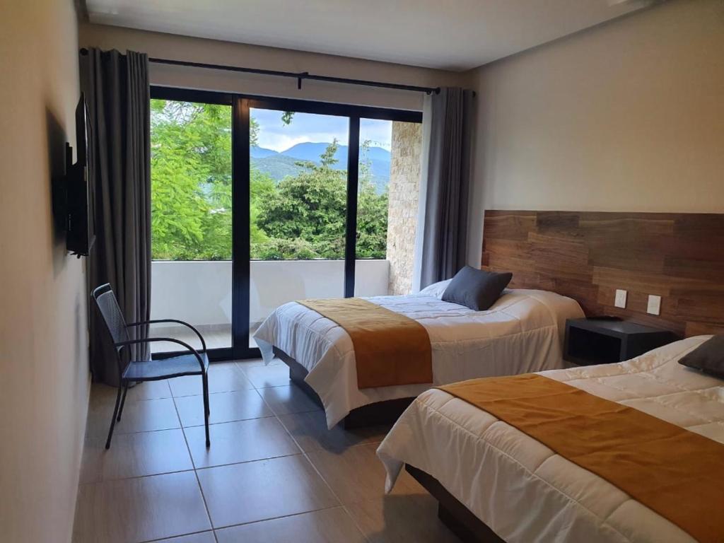 加尔潘Kali Secreto的酒店客房设有两张床和大窗户。