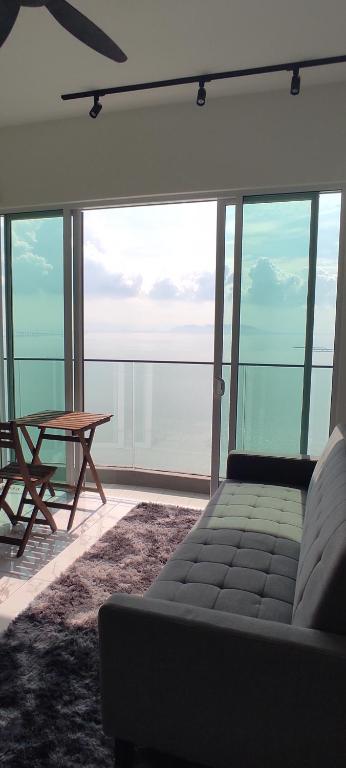 峇六拜Infinite Seaview with Penang Bridge Suite with Sunrise up to 11 person的客厅配有沙发和桌子