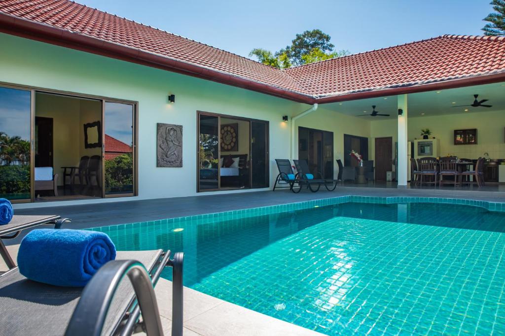 湄南海滩Villa Zen Island的一个带椅子的游泳池以及一座房子