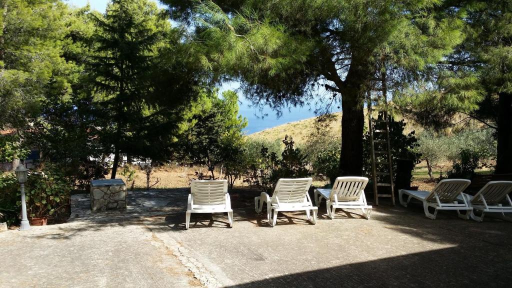 斯克佩罗Villa Sarmuci, Mare Natura Relax的一组坐在树下白色椅子
