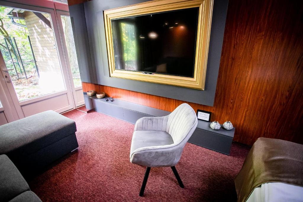多瑙新城Motel 1的客厅配有椅子和电视