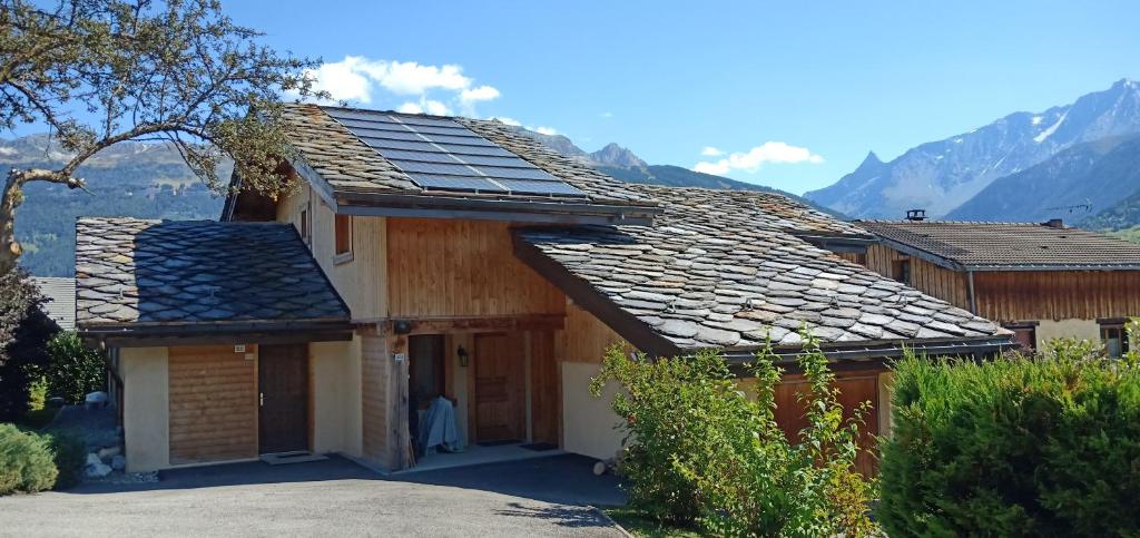 Les ChapellesMaison cœur tarentaise的屋顶上设有太阳能电池板的房子