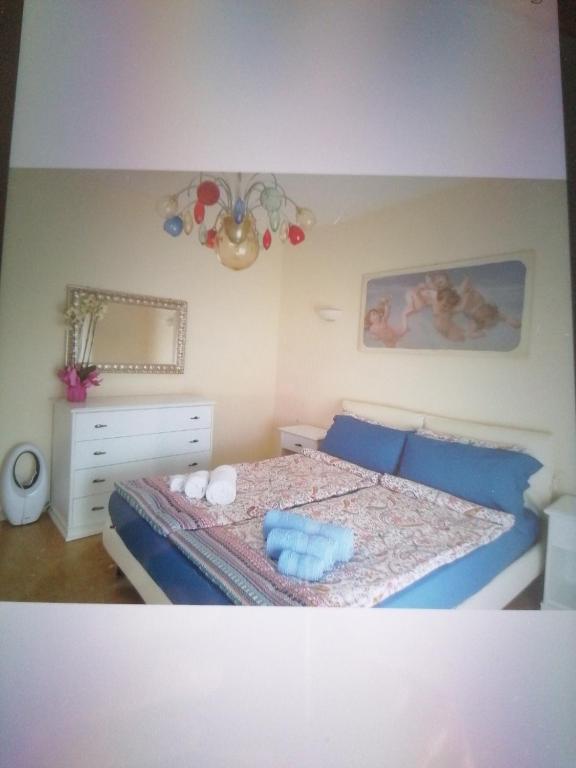 托里德尔贝纳科Casa Silvio的一间卧室配有一张带蓝色床单和蓝色枕头的床。