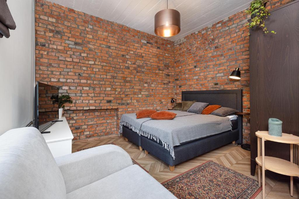塔尔图Peetri Apartments的一间卧室设有砖墙和一张床