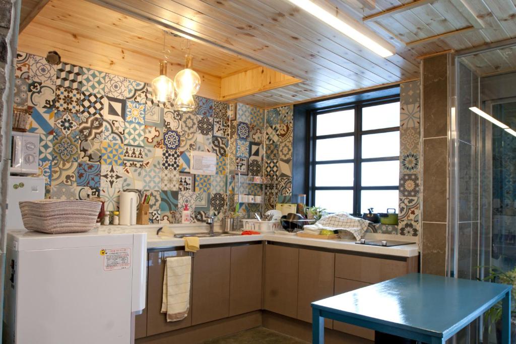 首尔Twin Rabbit Guesthouse的带冰箱和桌子的厨房