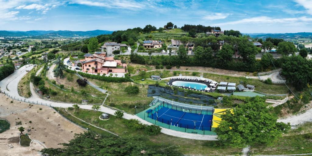 卡斯泰洛城Agriturismo Villa Paradiso Esotico的享有山丘上房屋的空中景致,设有游泳池