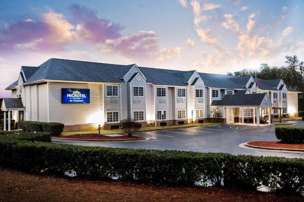 南派恩斯Microtel Inn & Suites by Wyndham Southern Pines Pinehurst的一座大型白色建筑,设有停车场