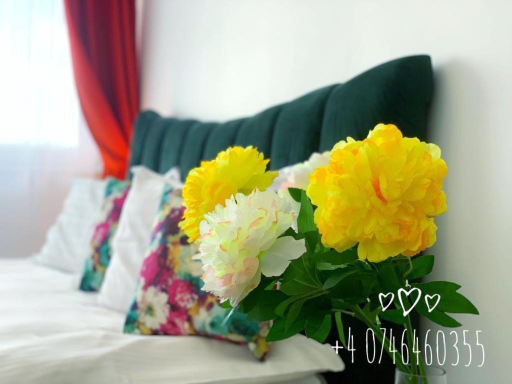克卢日-纳波卡红屋酒店的长沙发上满是黄白色花的花瓶