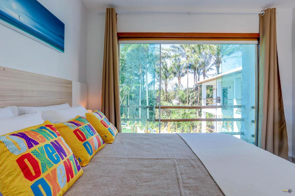 巴拉格兰德Pousada Céu & Mar de Taipu的一间卧室设有一张大床和大窗户