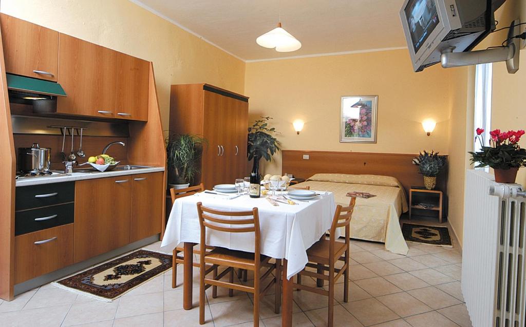 托雷佩利切普罗旺斯公寓式酒店的厨房以及带桌子和床的用餐室。