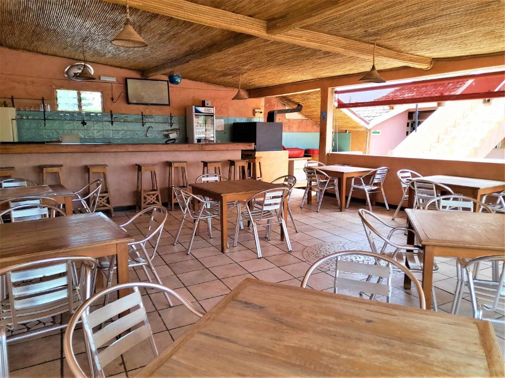 萨利波图尔Auberge Le Baobab的一间在房间内配有桌椅的餐厅