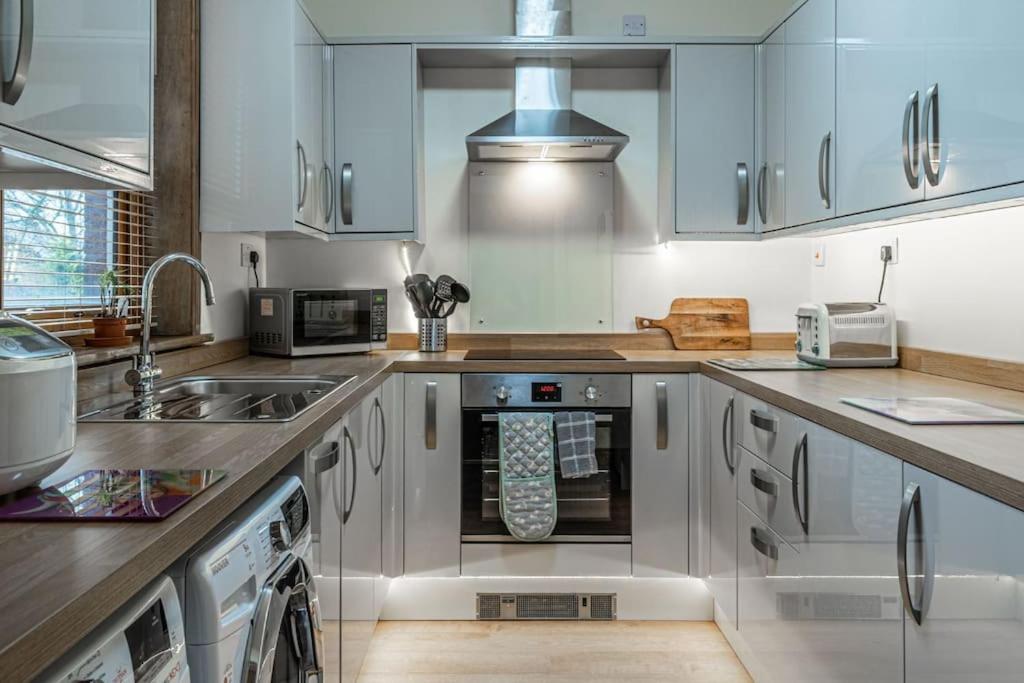 乔利Contractors accommodation in Chorley by Lancashire Holiday Lets的厨房配有白色橱柜和水槽