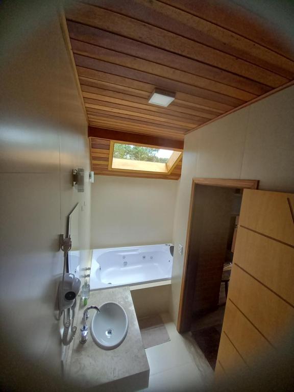 蒙特韦尔迪Chalé Caminho da Fonte的浴室配有盥洗盆和浴缸。