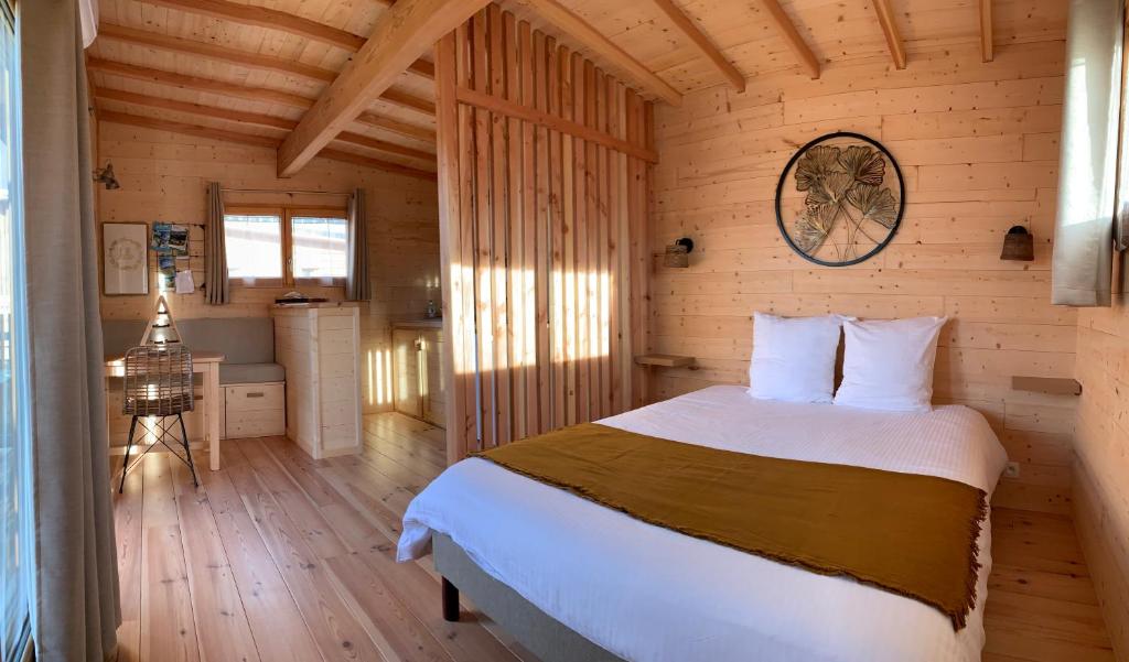 VirigninLes Lodges de la ViaRhôna / cabane-spa的小木屋内一间卧室,配有一张床