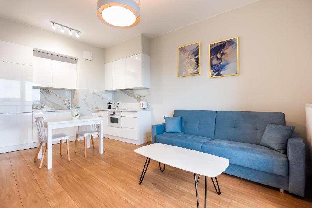 华沙Wola Lush Apartment的客厅配有蓝色的沙发和桌子