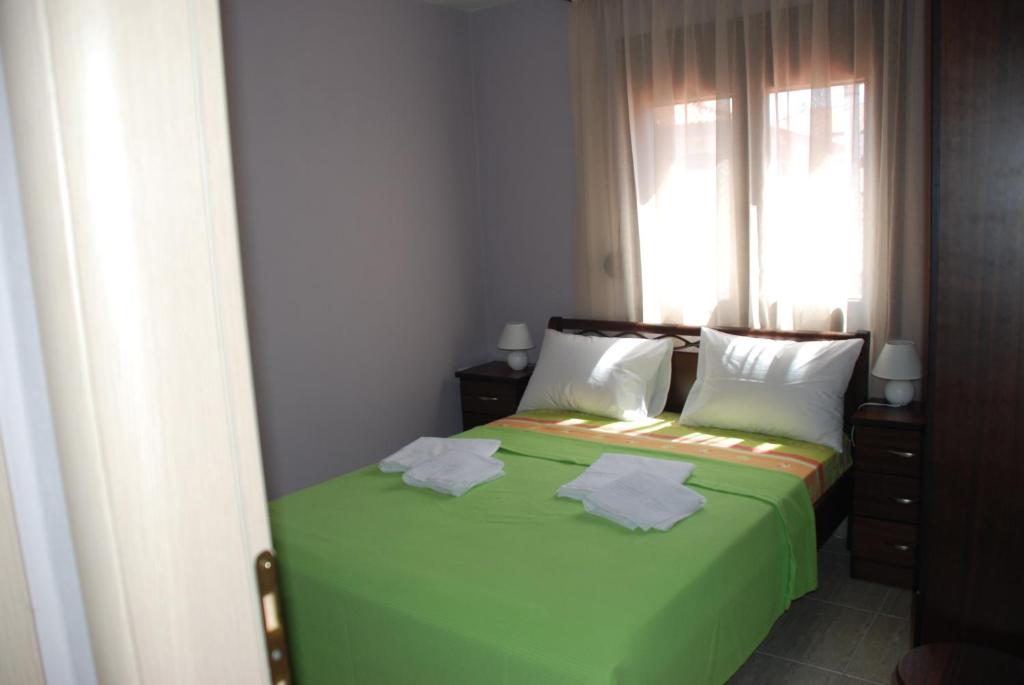 依诺罗达Marianna Apartments的一间卧室设有一张带窗户的绿色床