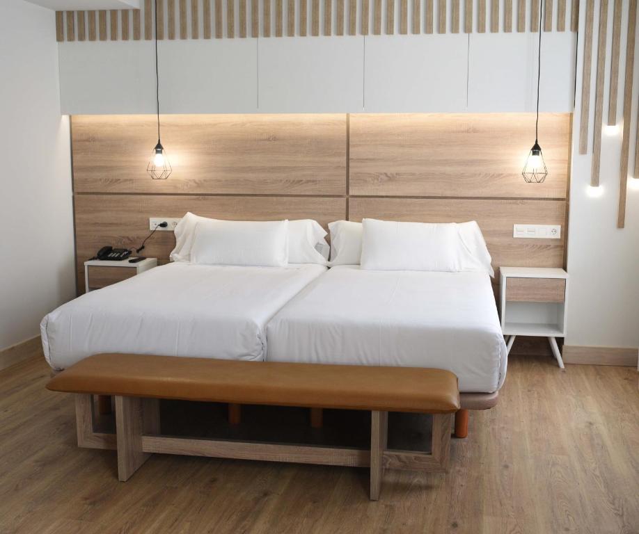 奥伦塞IMI Hotel & Spa的卧室配有一张白色大床和木制床头板