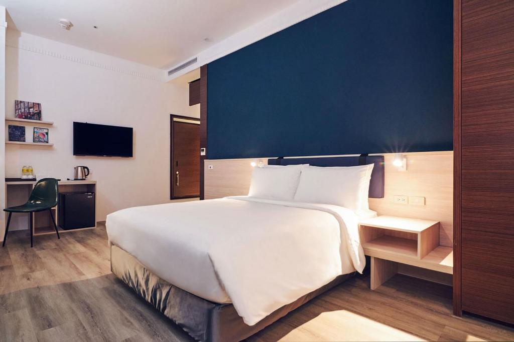 台北雀客藏居台北南港的一间卧室设有一张蓝色墙壁的大床