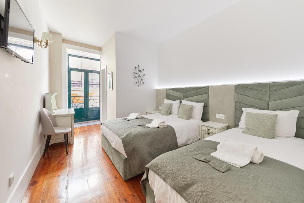 波尔图A Portuguesa Guest House的酒店客房设有两张床和窗户。