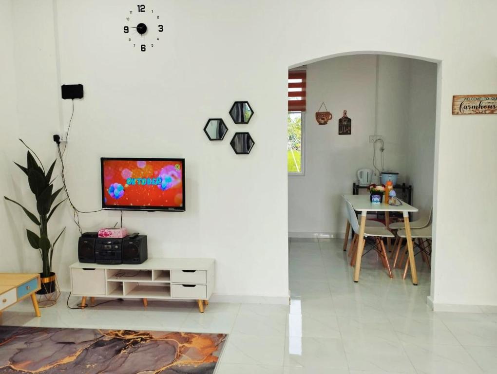 Pasir MasHomestay Berkat D'sawah Tasek Berangan Pasir Mas的一间客厅,在白色的墙上配有电视