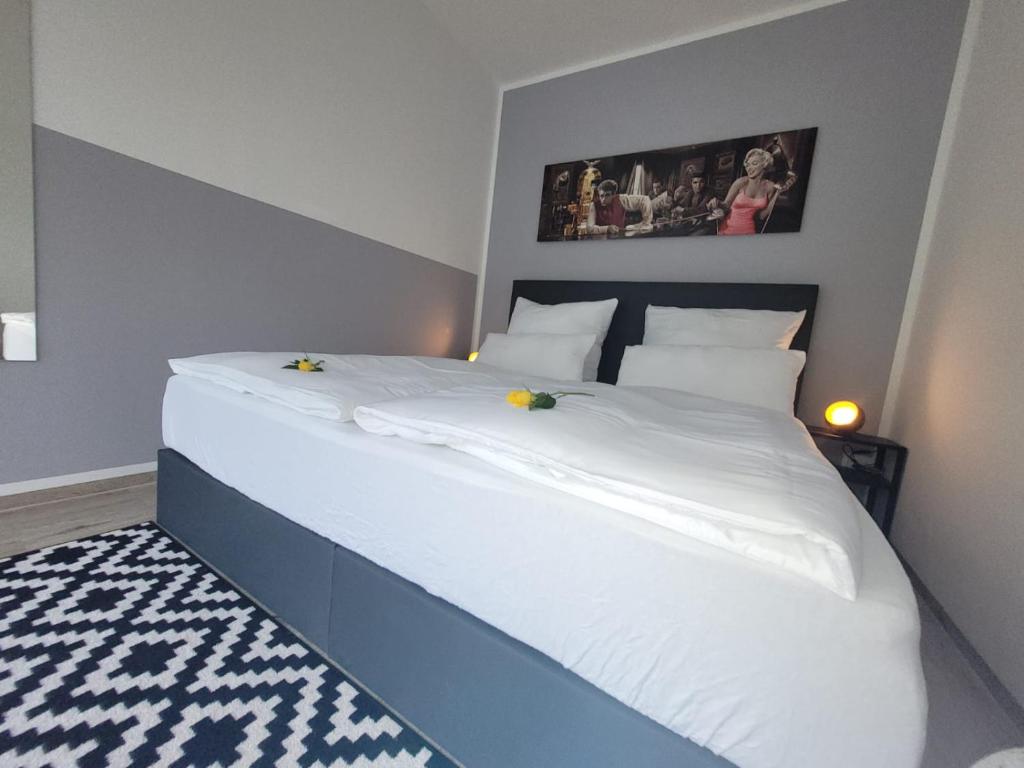 巴德克洛斯特尔劳斯尼茨Ferienwohnung Holzland的一间卧室配有一张大白色床,上面有两只鸭子