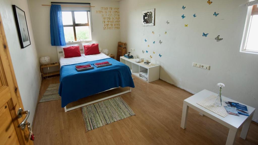 霍芬Dynjandi Guesthouse的一间卧室配有一张带蓝色床单的床和一扇窗户。
