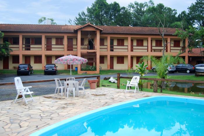雅瓜里乌纳Pousada Circuito das Aguas的一个带游泳池、椅子和遮阳伞的酒店