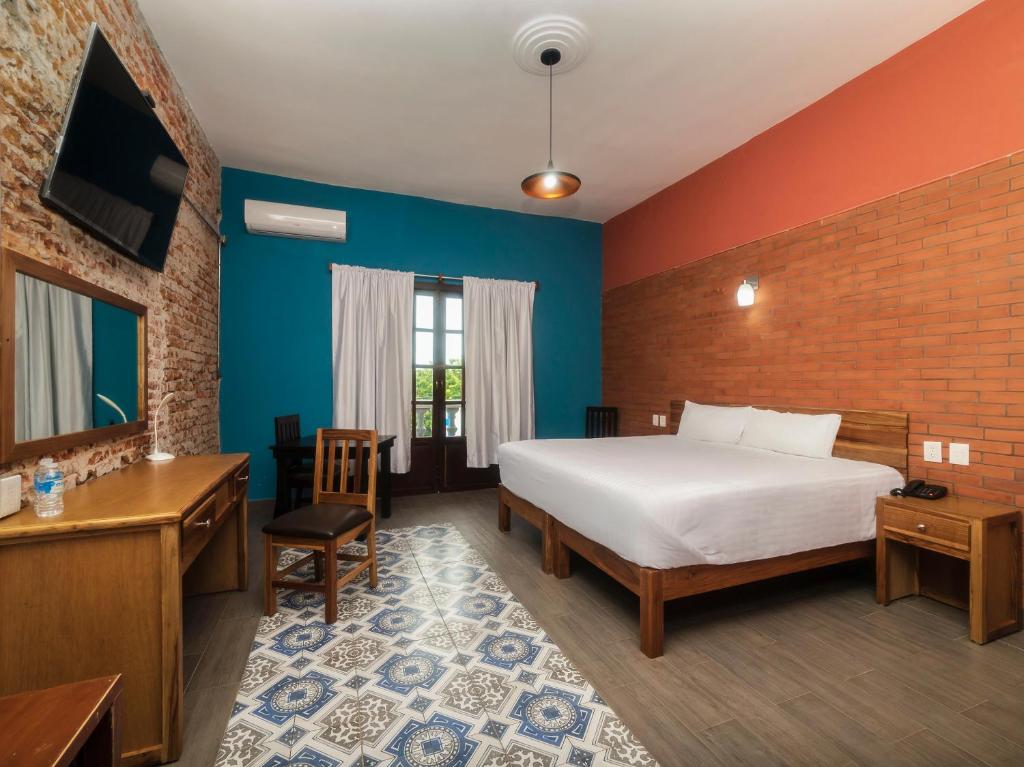 韦拉克鲁斯Hotel Meson del Barrio的一间卧室配有一张床、一张书桌和一台电视