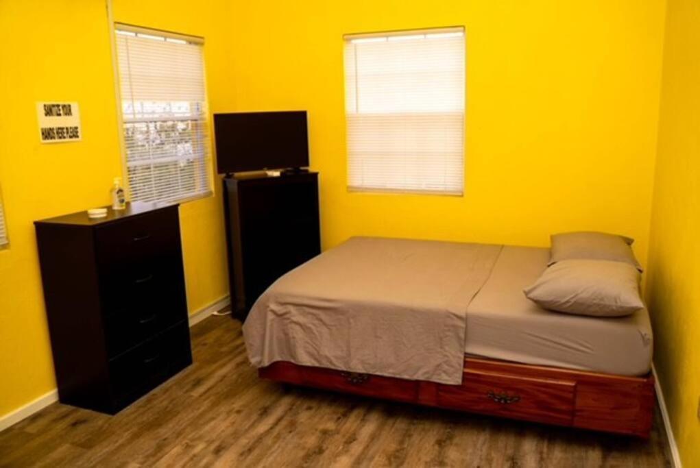LaborieGlasgow Villa at La Mar的卧室拥有黄色的墙壁,配有一张床和梳妆台
