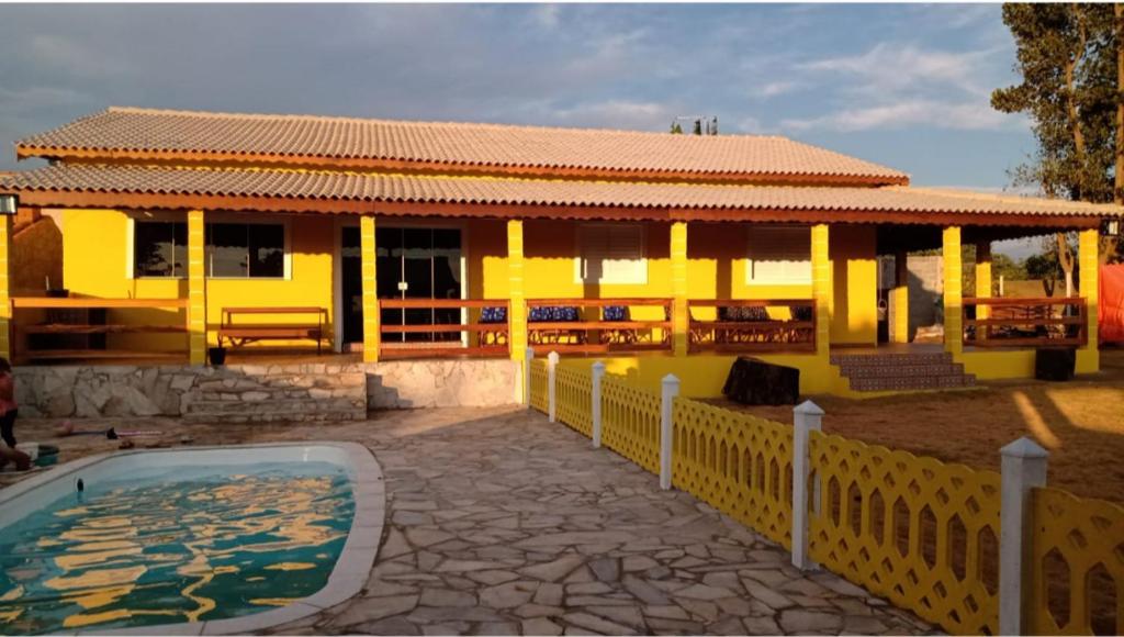 Salto de PiraporaChacara em Salto de Pirapora Condomínio Arco Íris的一座黄色的房子,前面有一个游泳池