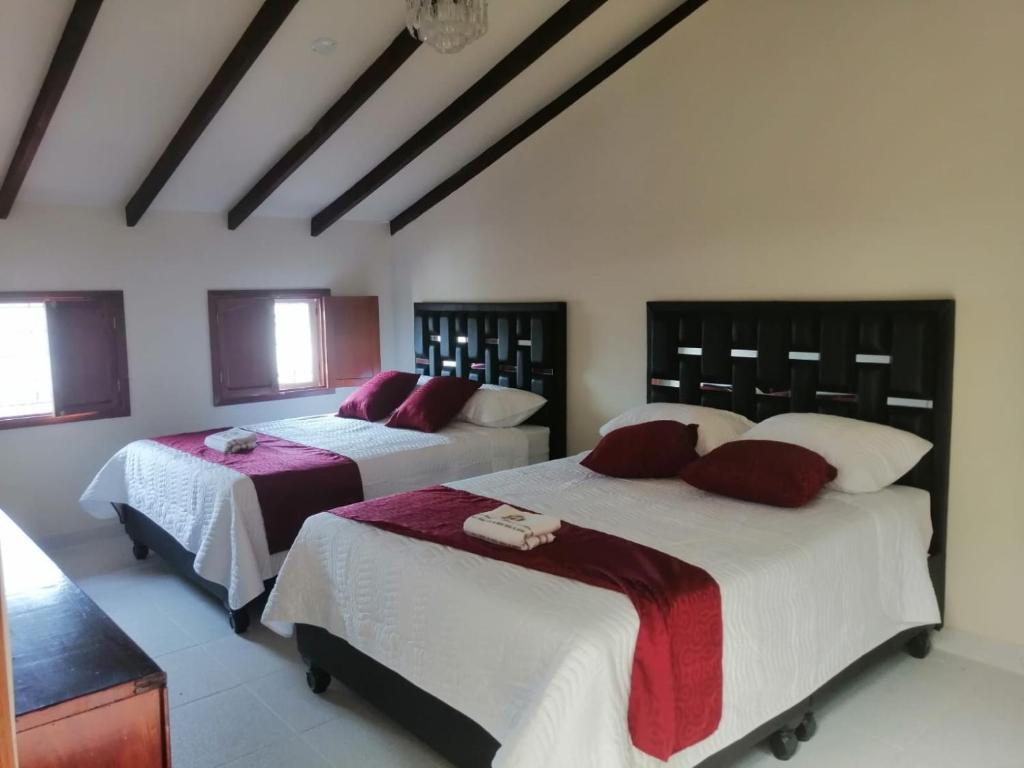 波帕扬Hotel Castillo Real的一间卧室配有两张红色和白色床单
