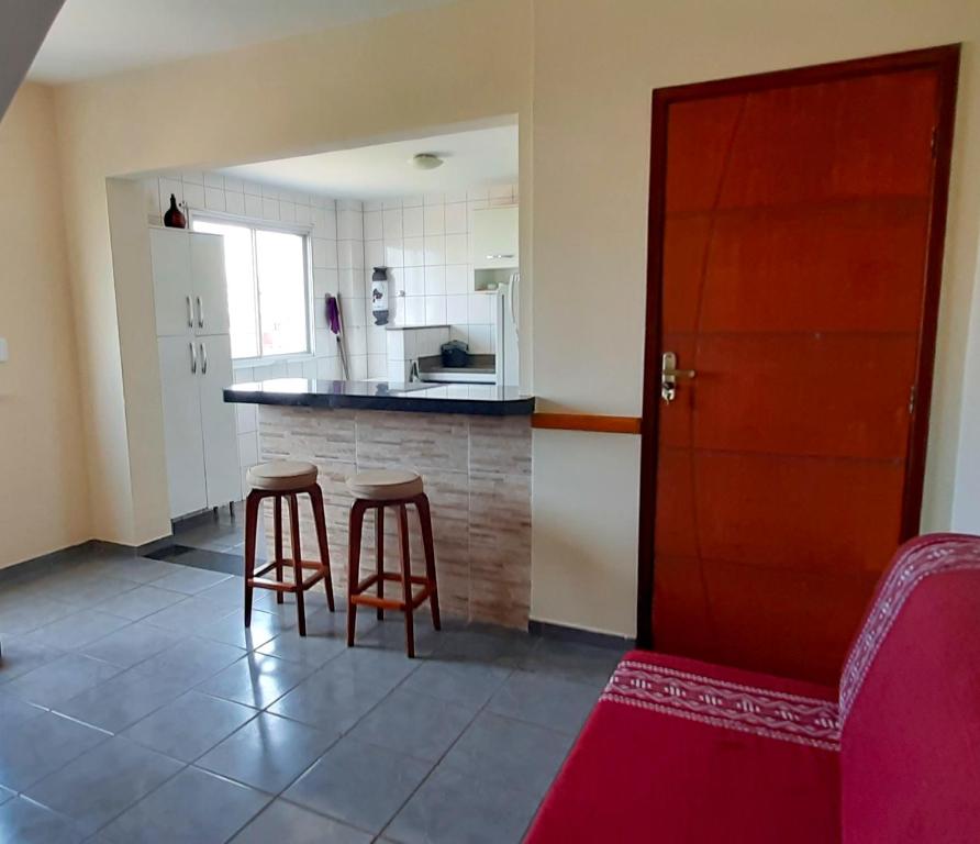 瓜拉派瑞Apartamento super arejado na Praia do Morro的一间厨房,内设一个柜台和两个凳子