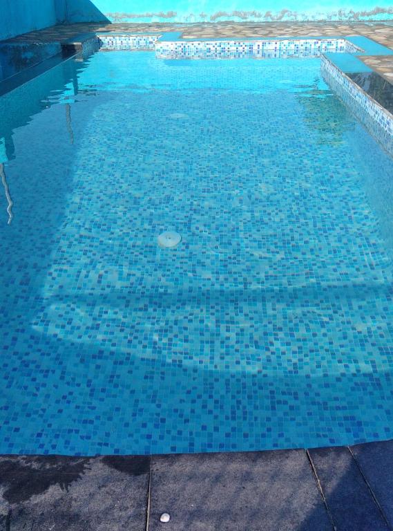 JhirnaCorbett Bhavesh home Stay的水面上蓝色瓷砖的游泳池