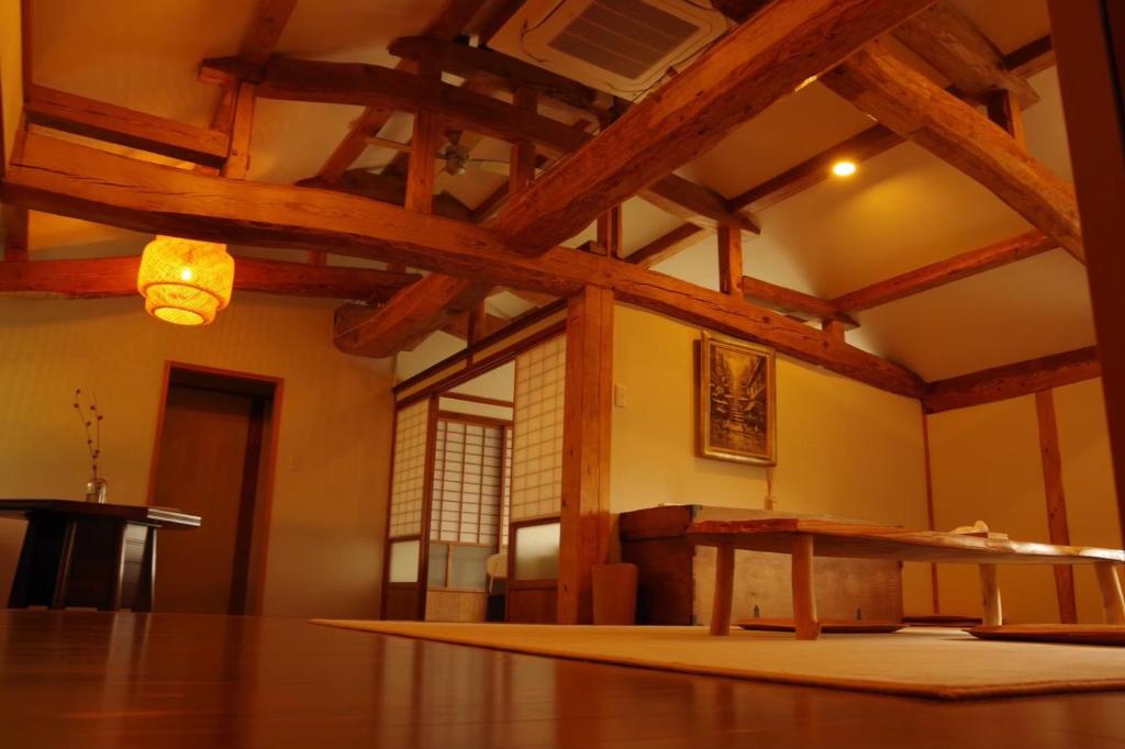 壹岐市島宿糸的客房设有桌子和木制天花板。