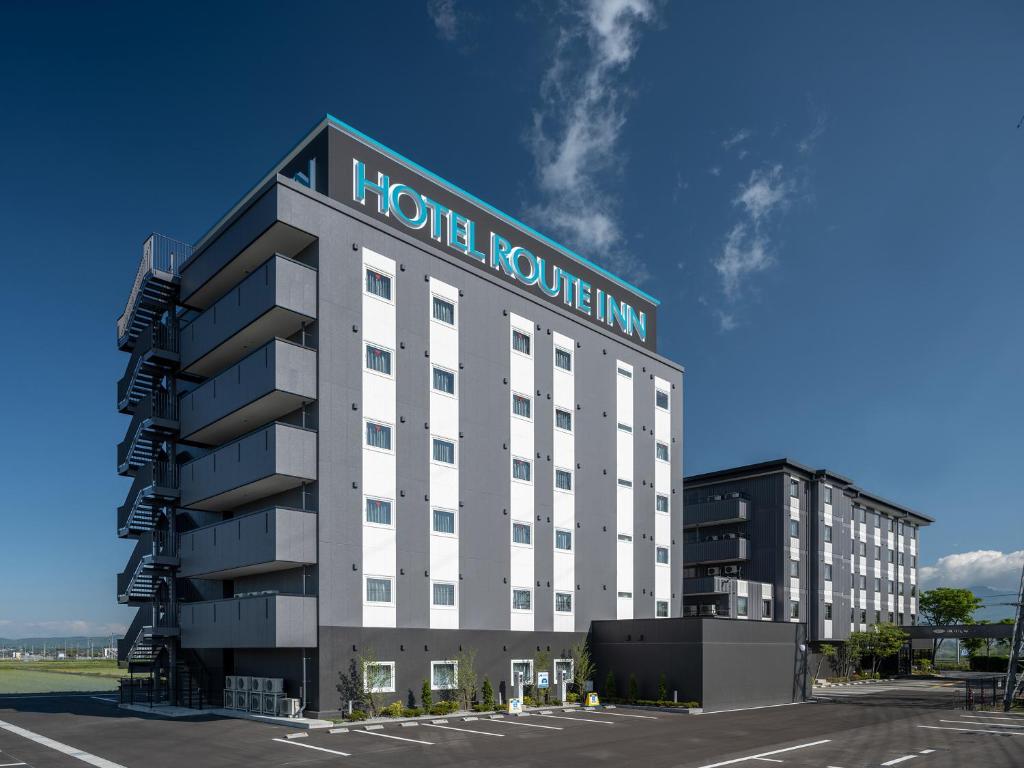 佐久市Hotel Route-Inn Saku Minami Inter的酒店流动性旅馆,前面设有停车场