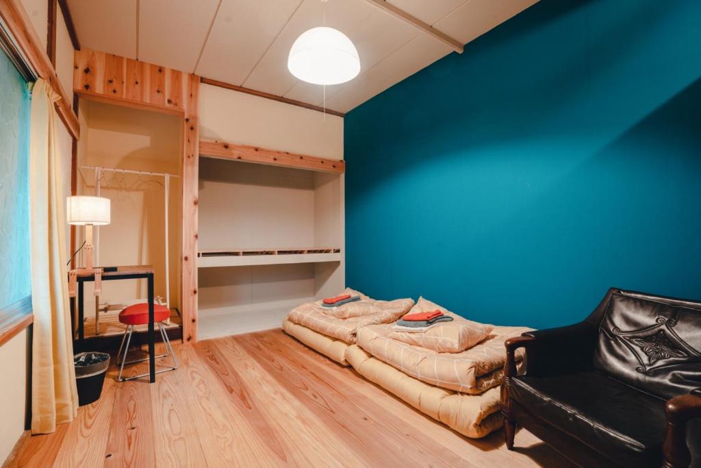 气仙沼市SLOW HOUSE kesennuma - Vacation STAY 31901v的一间配有沙发和蓝色墙壁的客房