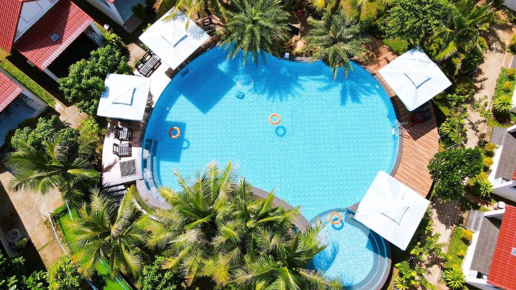 富国Fla Village的享有带遮阳伞和棕榈树的游泳池的顶部景致