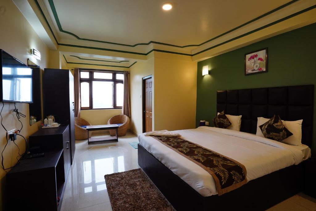 甘托克Hotel White Lotus Gangtok的一间卧室设有一张带绿色墙壁的大床