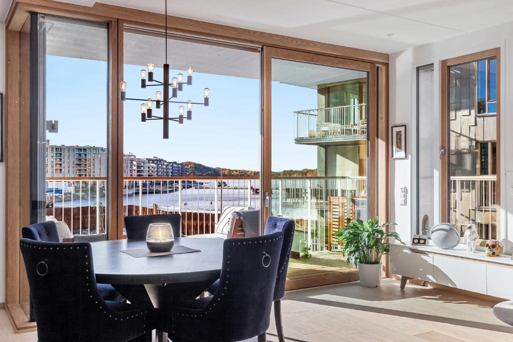 奥斯陆Amazing luxury apartment on the waterfront! 73sqm的一间带桌椅和大窗户的用餐室