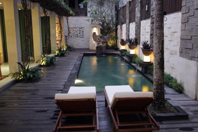 乌布Cinta inn的庭院内的游泳池,配有2把躺椅