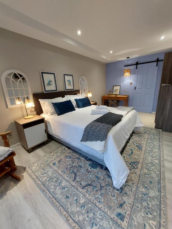 东伦敦Coral Tree Boutique Guesthouse的一间卧室配有一张大床和地毯。