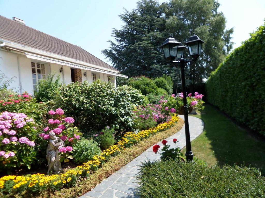 Sommervieu莱普茨贝森诺曼底旅馆的一个带灯柱和鲜花的花园