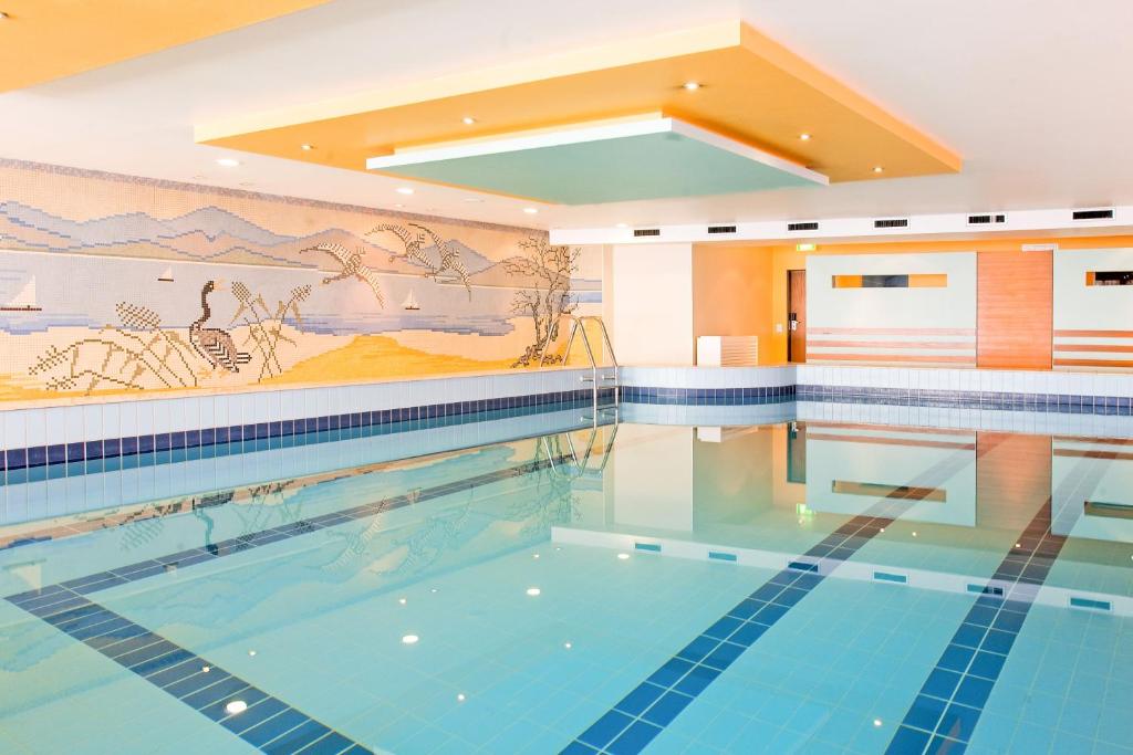 科隆莱斯基辰酒店的墙上挂有壁画的游泳池