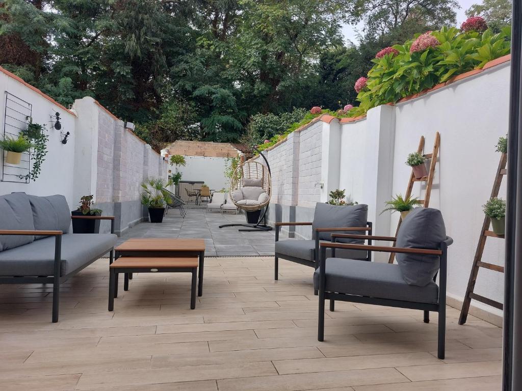 阿维莱斯El Patio de Rivero con garaje, Avilés的庭院配有桌椅和植物