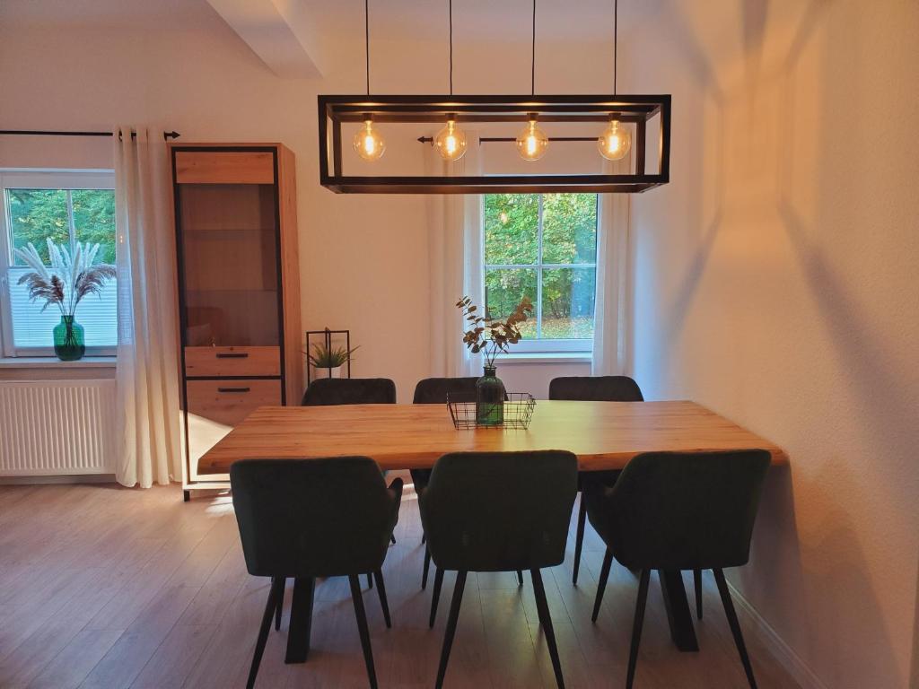 索尔陶Familienfreundliche Ferienwohnung Soltau的一间带木桌和椅子的用餐室
