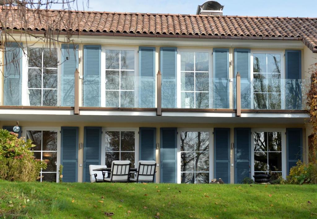 林道拉纳民宿的草坪上带蓝色窗户和椅子的房子